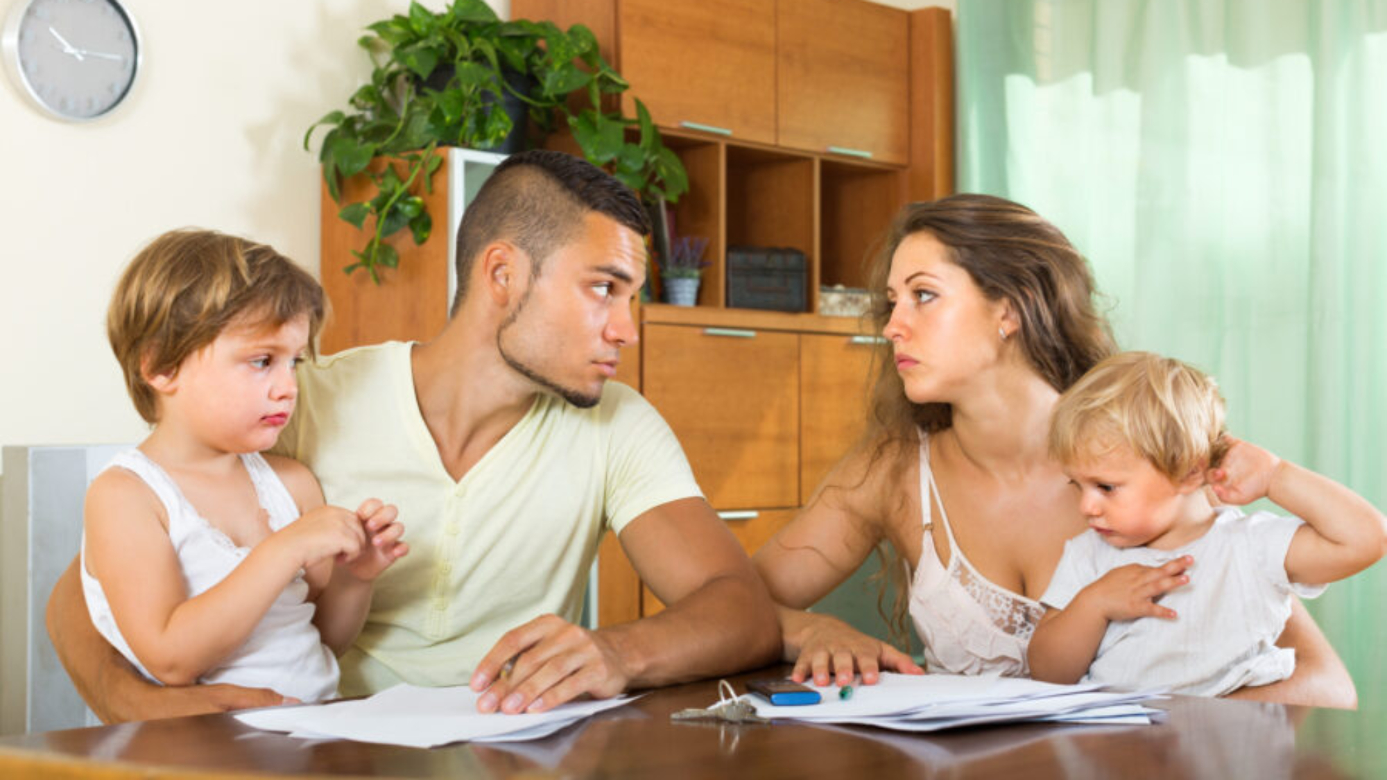 Married couple having quarrel in front of children at home
